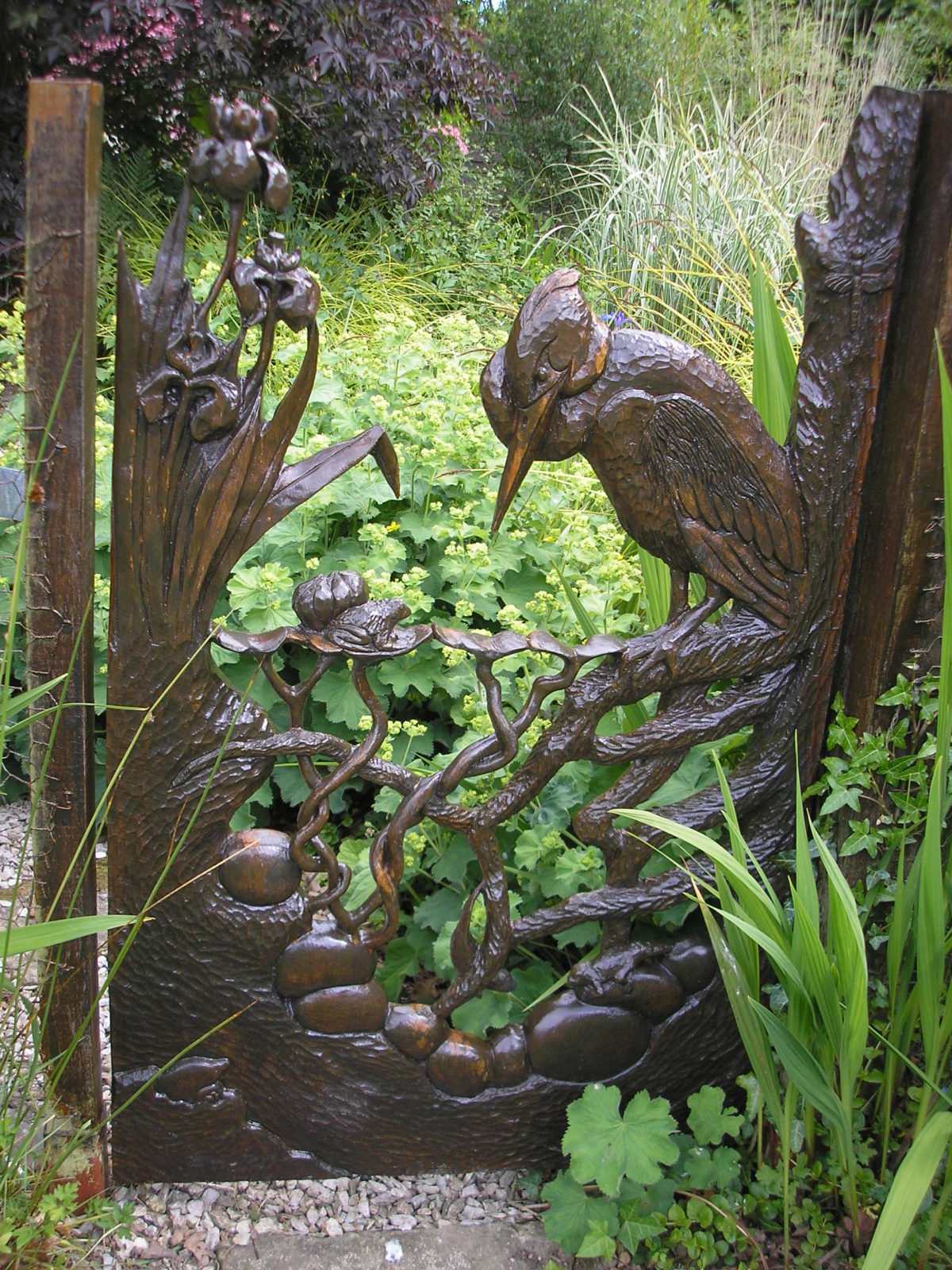 When we made our new pond, we fenced it off so our grandchildren would be safe and I then carved a gate which was kept locked while they were little, they are now taller than me! The carving shows a cross section of the pond with newts, frog and a heron.