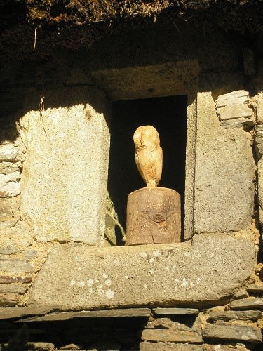 A carved owl in a niche in the wall of the walled garden.